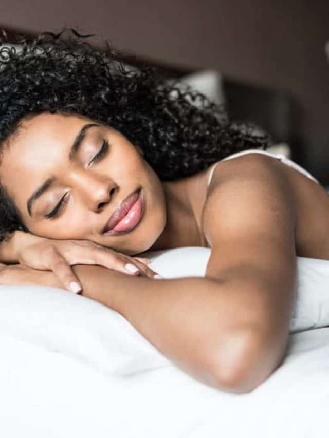 Woman,Happy,On,Bed,Smiling,And,Stretching,Looking,At,Camera