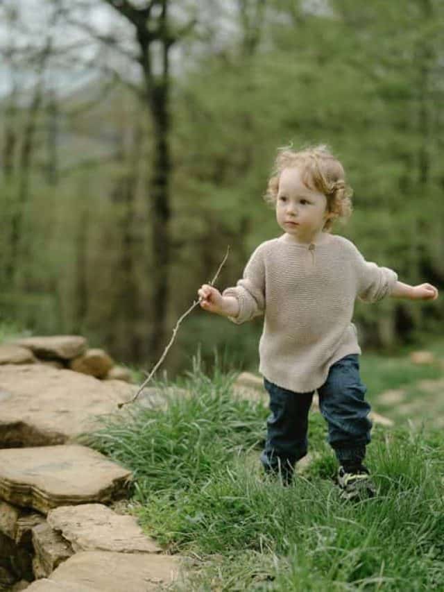 child-running-holdnig-a-stick