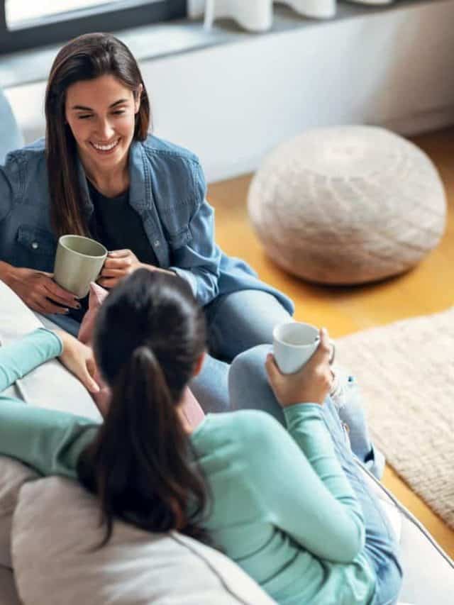 Shot,Of,Two,Smiling,Young,Women,Talking,While,Drinking,Coffee