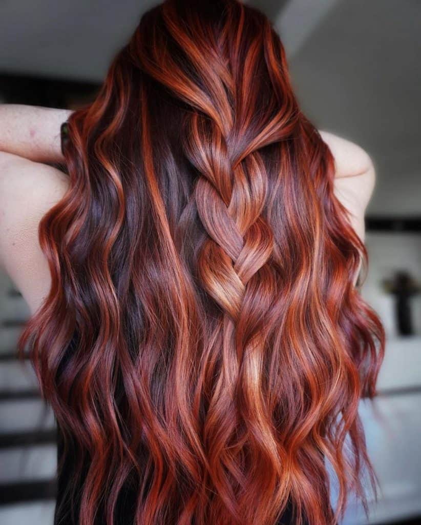A woman with long red hair and a braid, exuding elegance and charm.