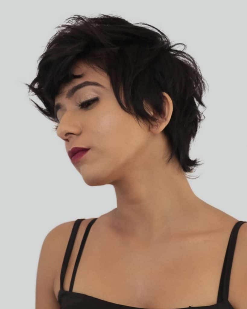 A woman with short black hair and a red lip, exuding elegance and confidence.