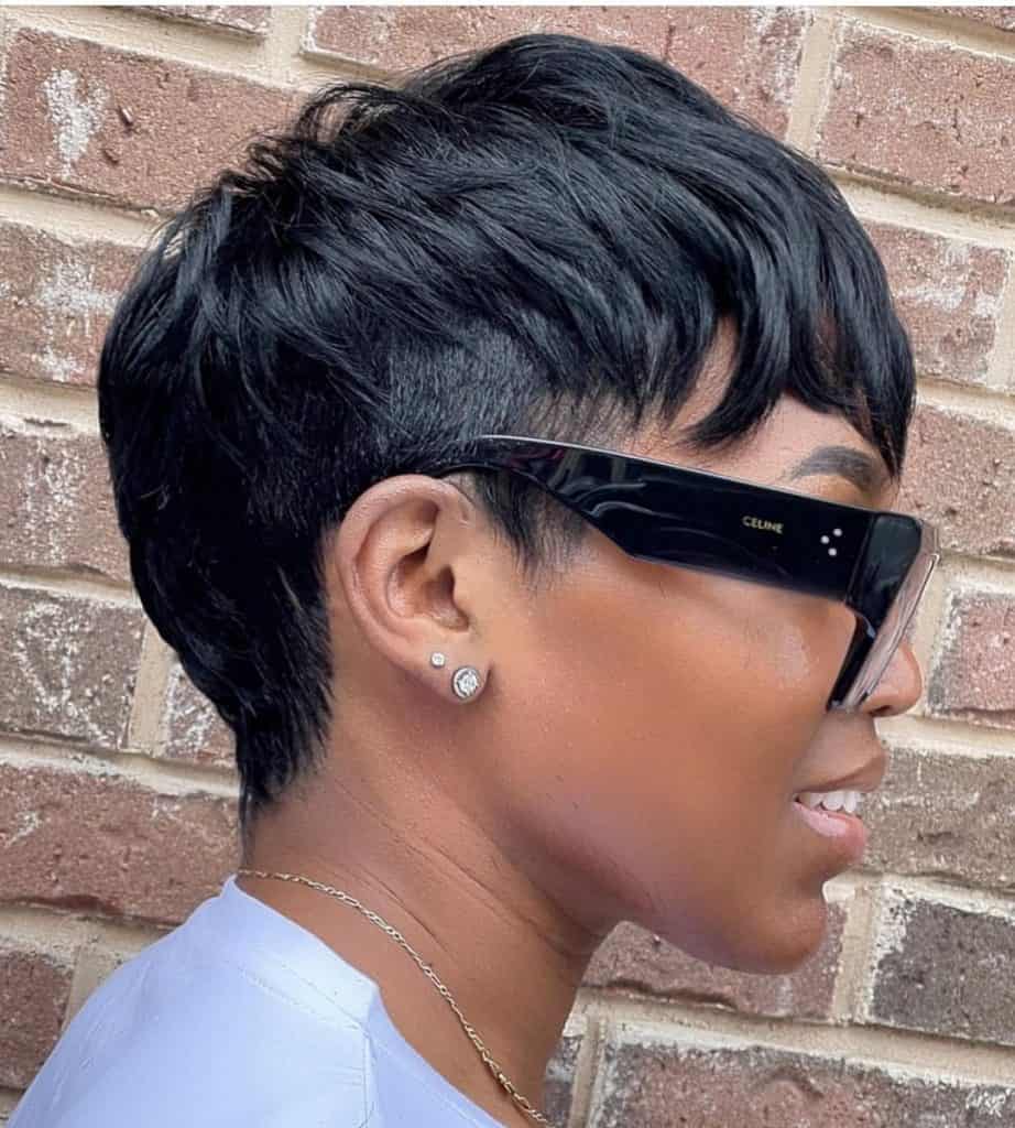 A stylish woman with short black hair and sunglasses.