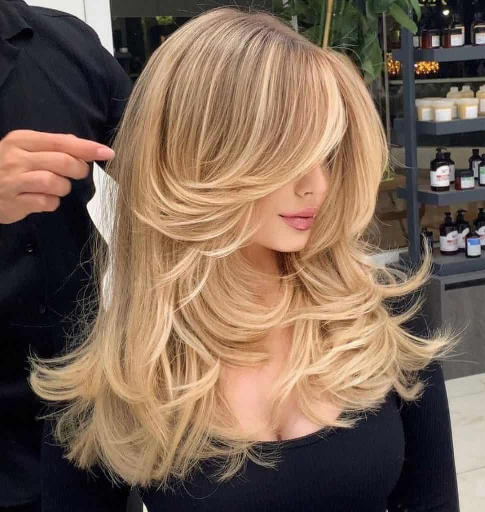 Blonde hair with long layers and a side part - a stylish hairstyle with cascading layers and a side parting.