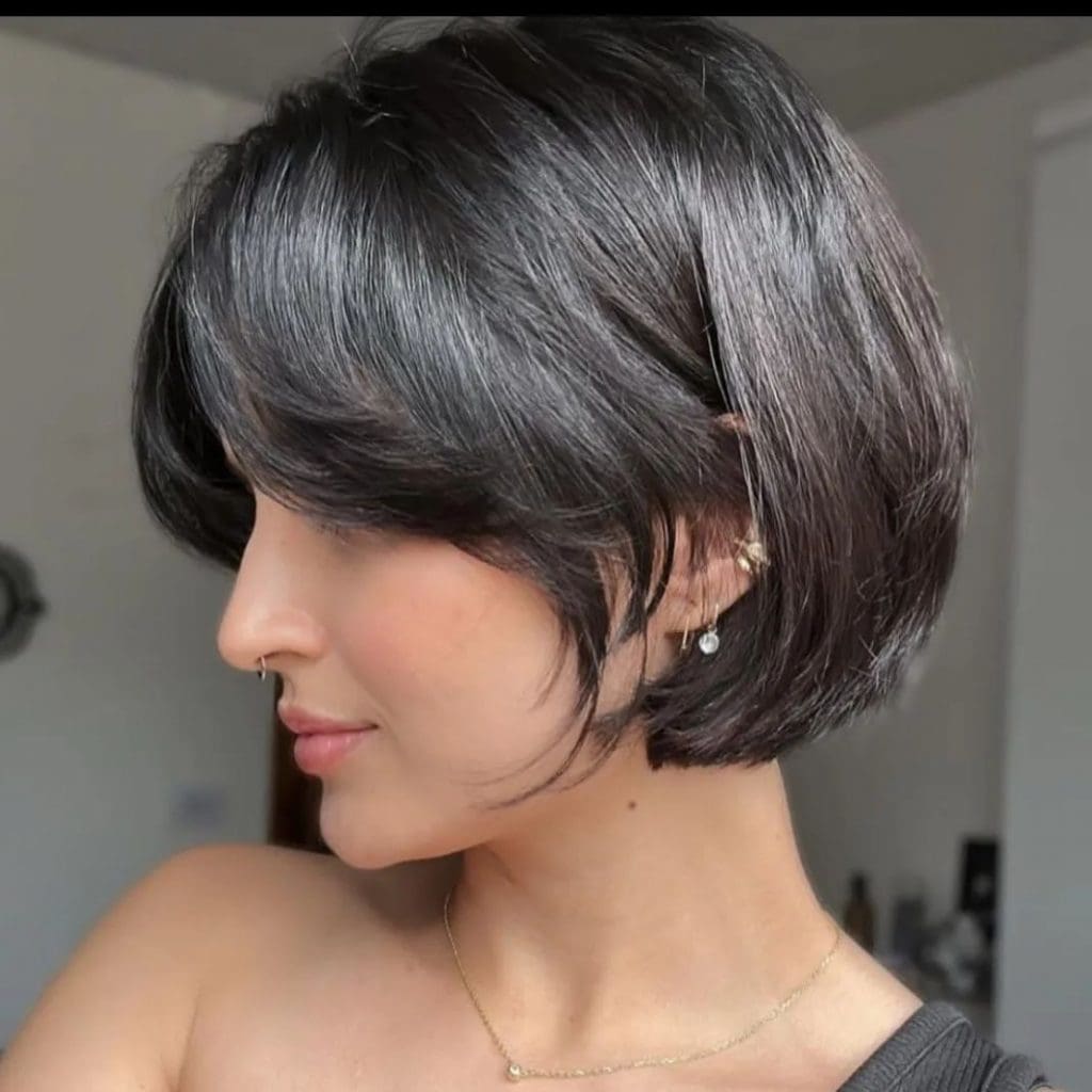 A woman with a short black hair cut, looking confident and stylish.