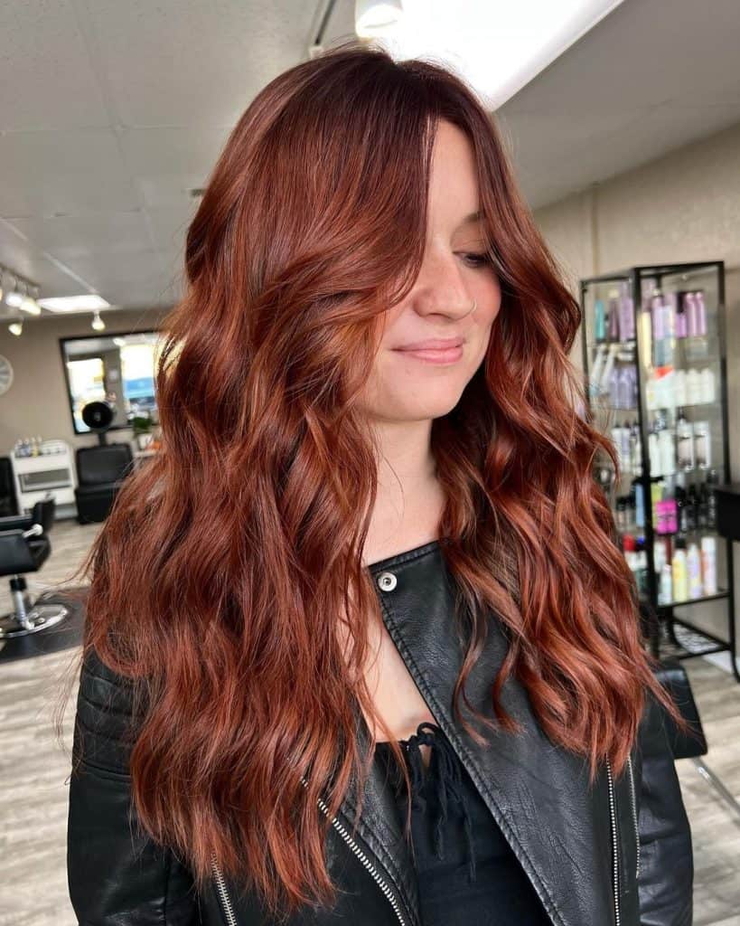 Woman with vibrant red hair having a salon appointment.