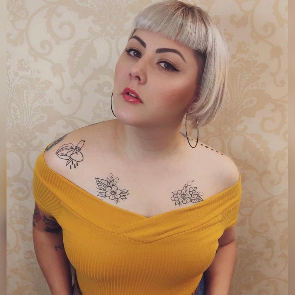 A woman with intricate chest tattoos, expressing her personal style.