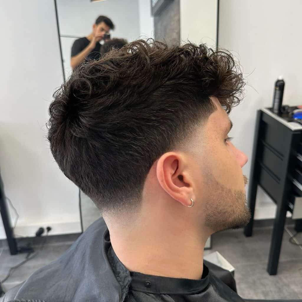 man with curly taper fade dark hair