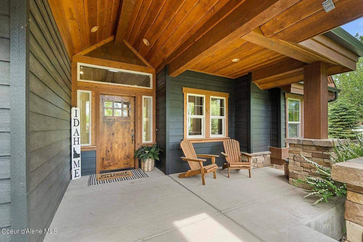 Front entry with wooden lounge chairs, a glazed front door, and a wood-paneled ceiling.