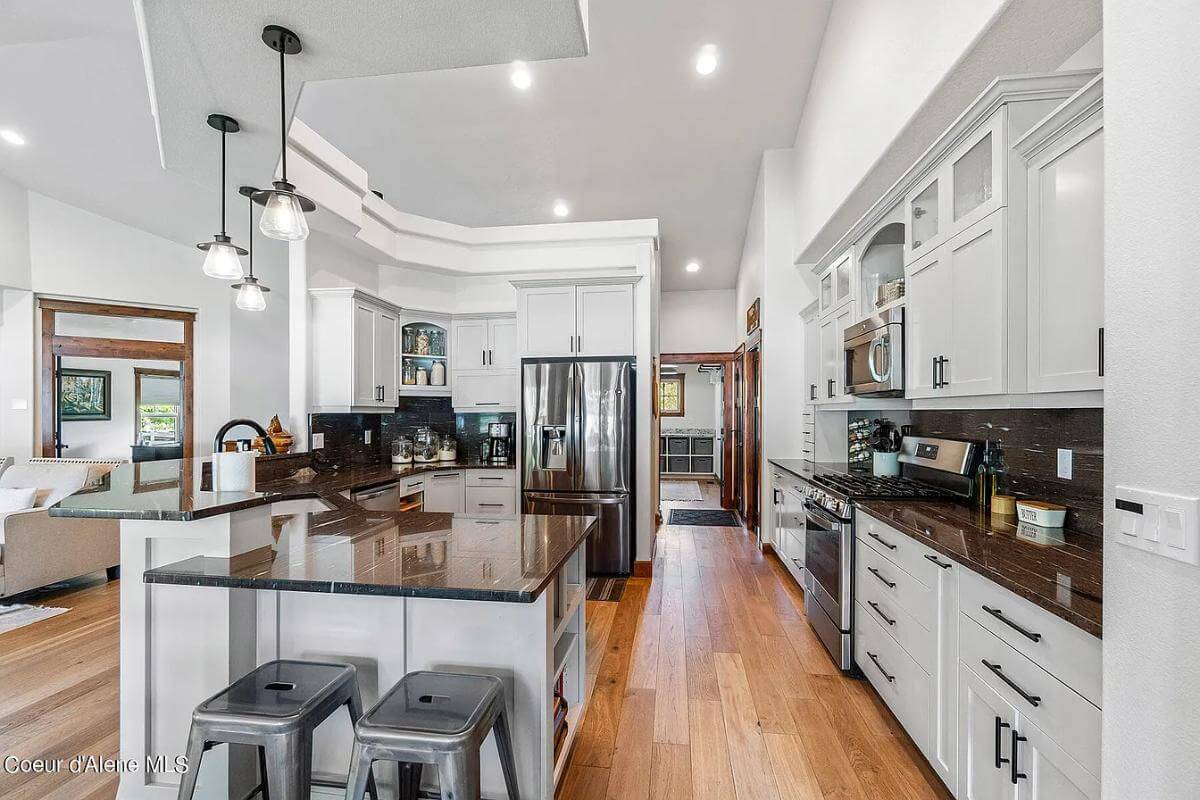 The kitchen includes stainless steel appliances and a snack bar with seating for two.