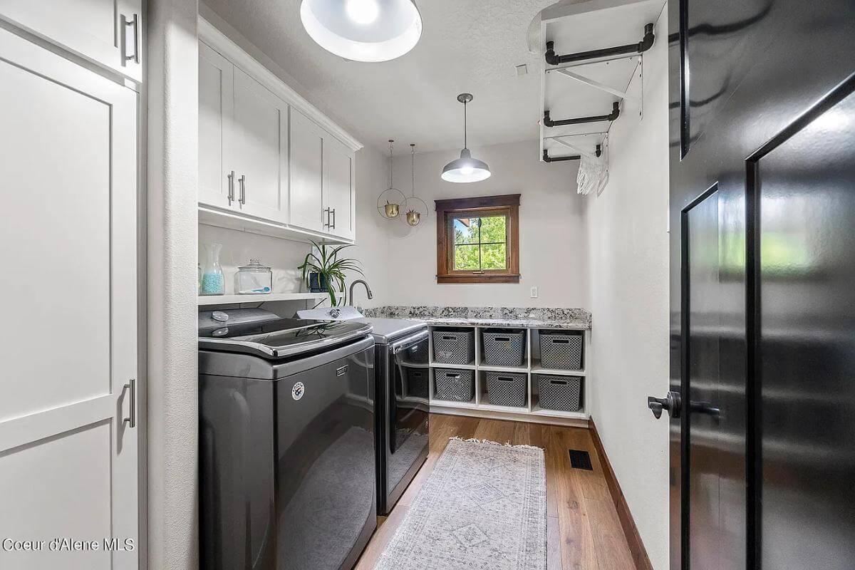 Laundry room with overhead cabinets and granite countertops.