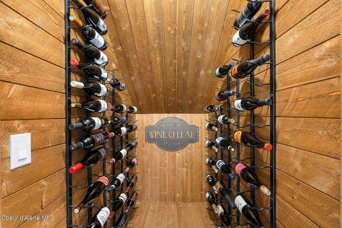 Wine cellar with iron racks fixed against the wood paneled walls.