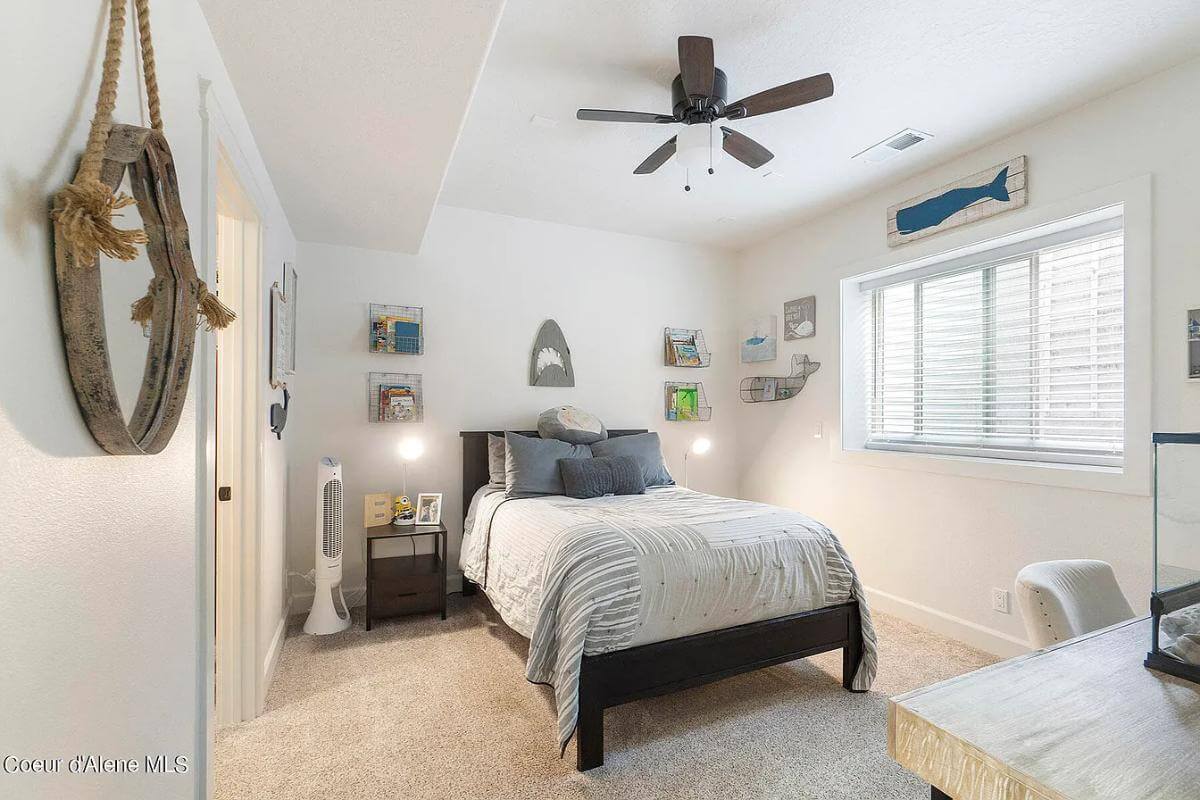 Bedroom with a dark wood bed and white walls adorned by metal shelves and a rustic hanging mirror.