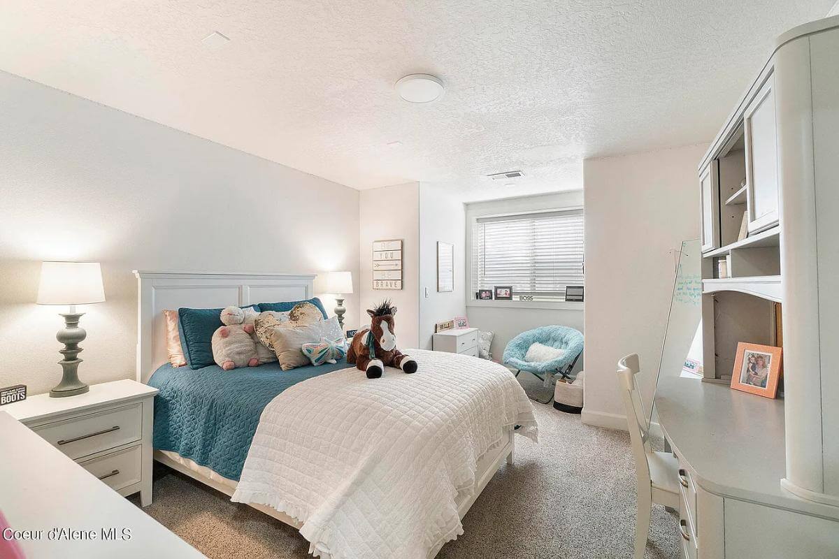 Bedroom with white furnishings over the carpeted floor.