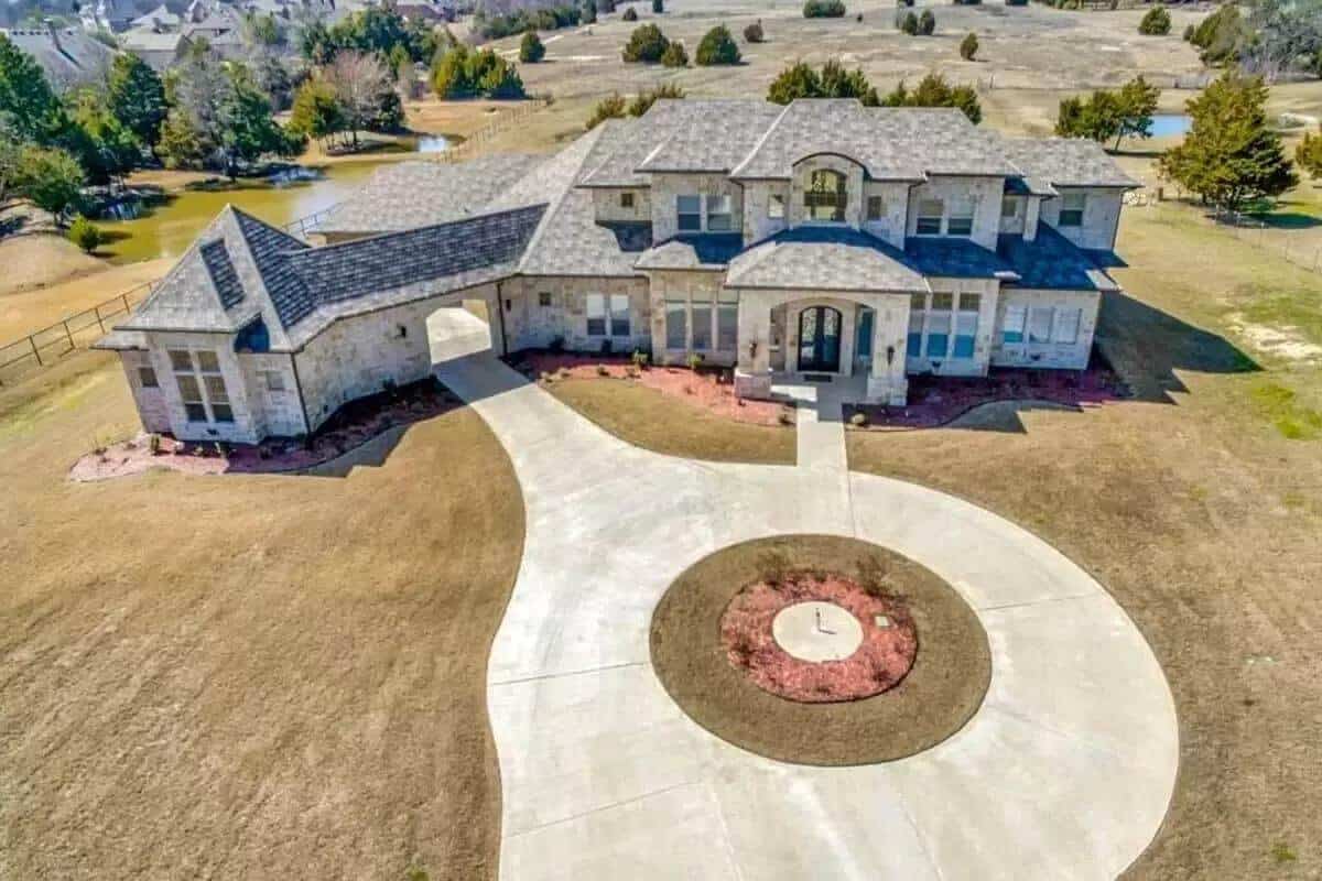 Front view with hipped rooflines, a gran entry, a porte-cochere, and a circular driveway.