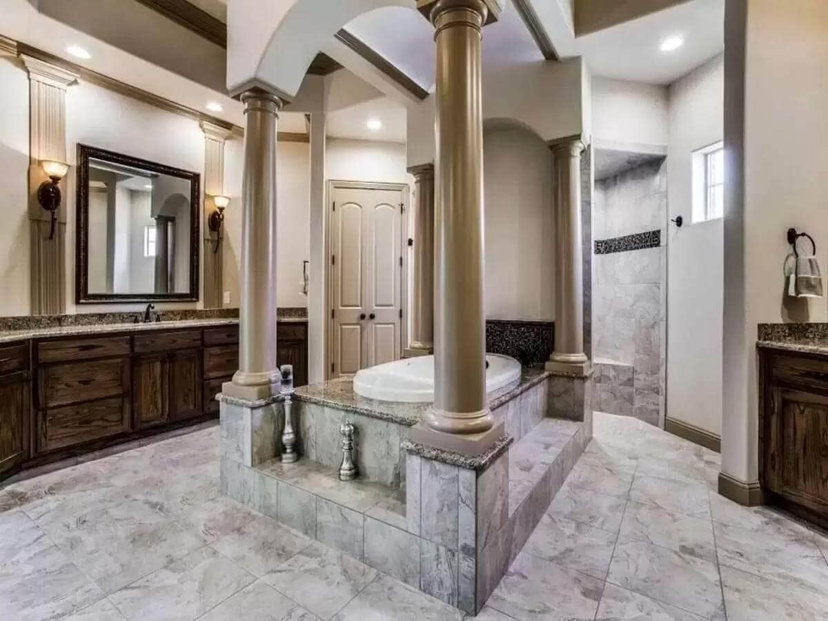 Primary bathroom with his and her vanities flanking the bathtub.