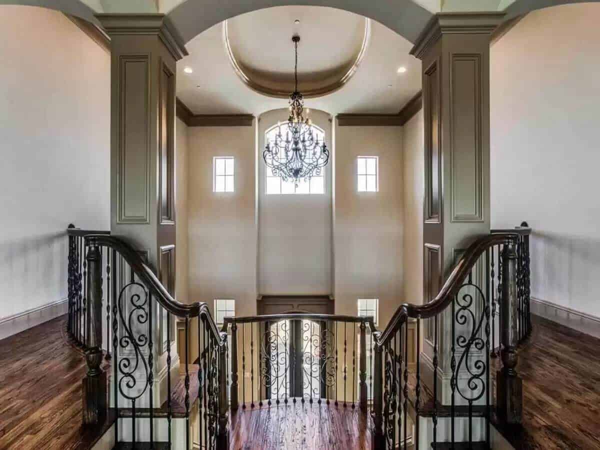 Balcony with intricate railings and a grand chandelier that hangs from the dome ceiling.