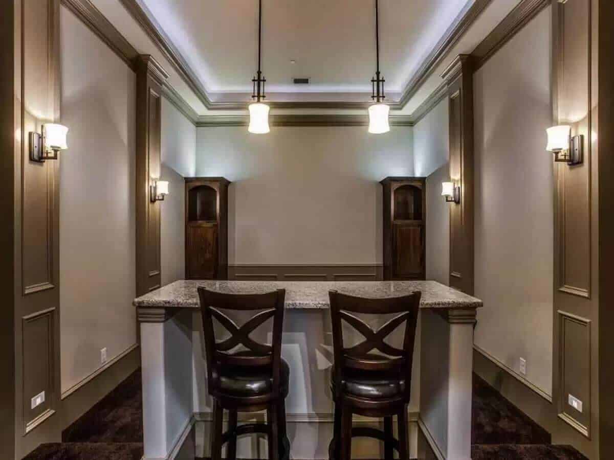 Wet bar with a granite countertop and seating for two.