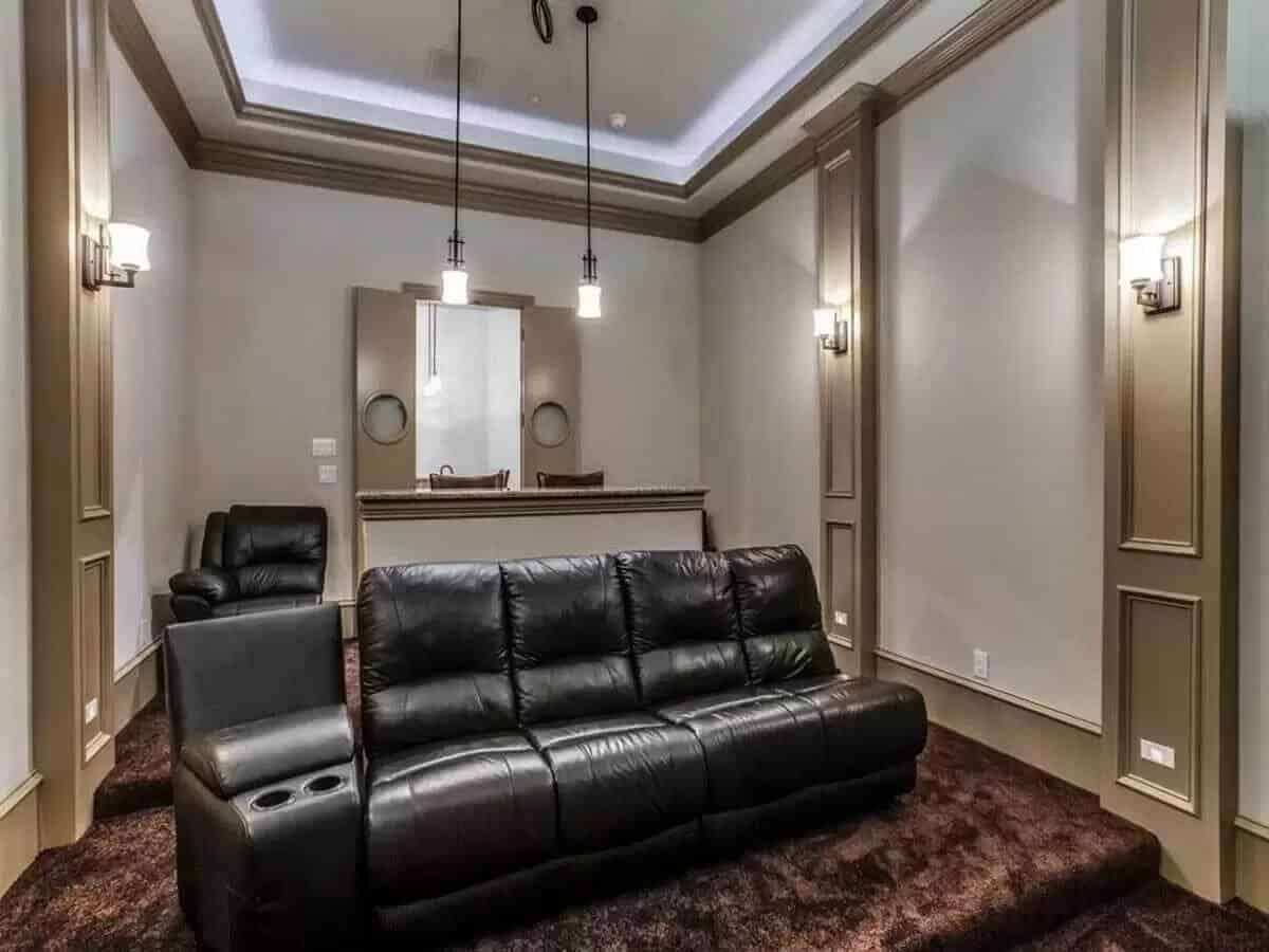 Media room with black recliners and a built-in bar.