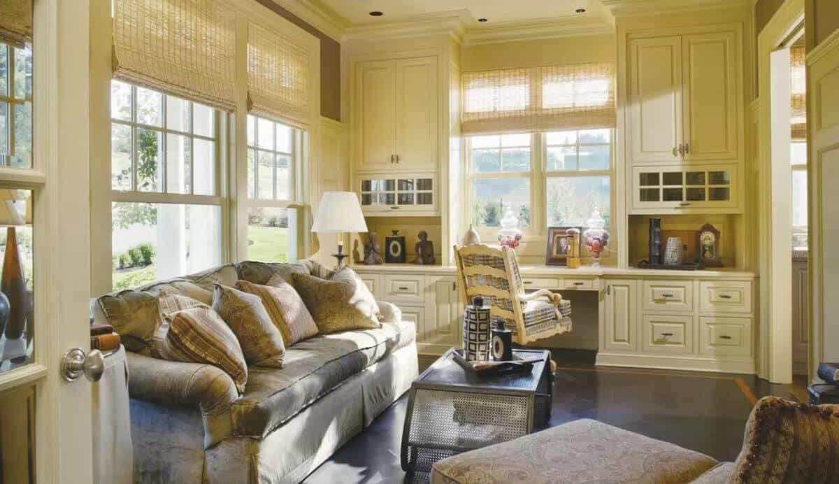 Office with a velvet sofa and a built-in desk against the window.