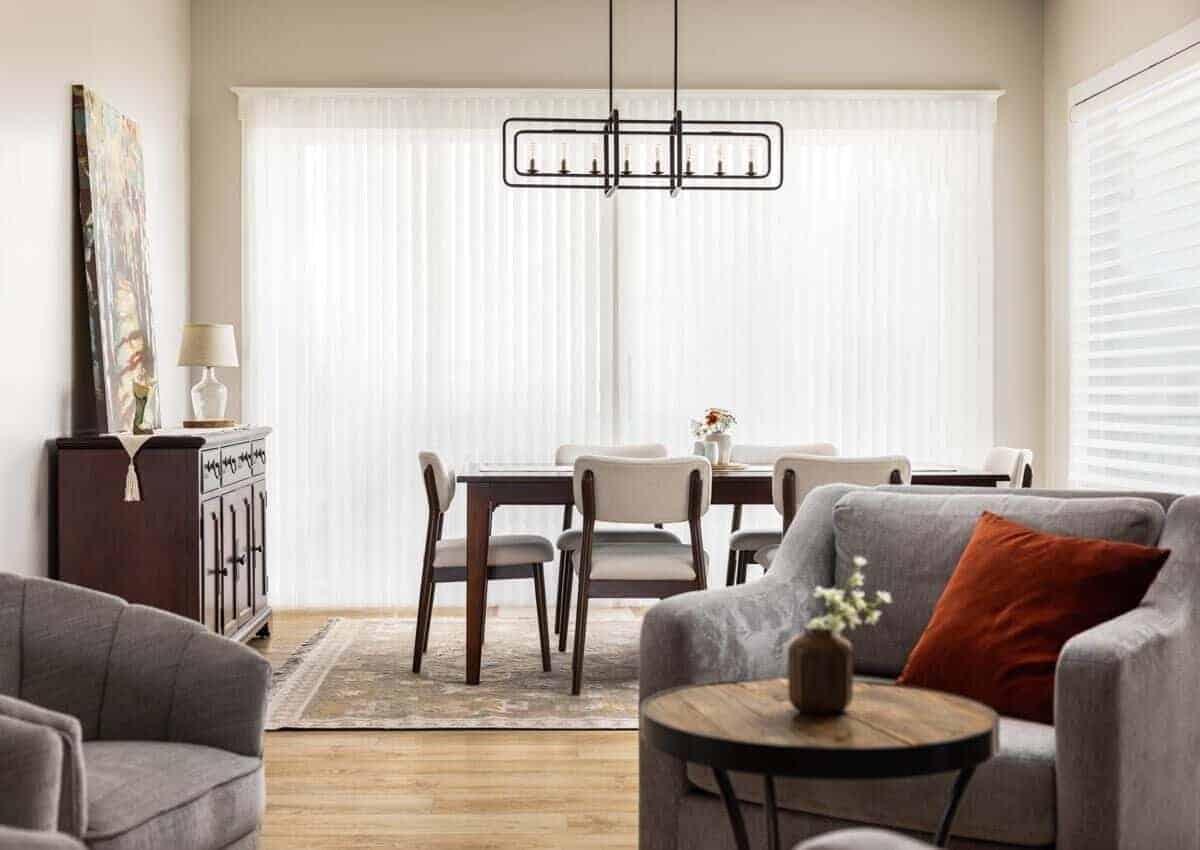 Sitting area and dining room with hardwood flooring and beige walls.