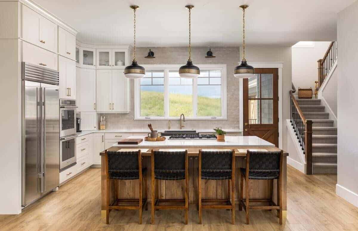 Kitchen with white cabinets, stainless steel appliances, and a breakfast island with seating for four.