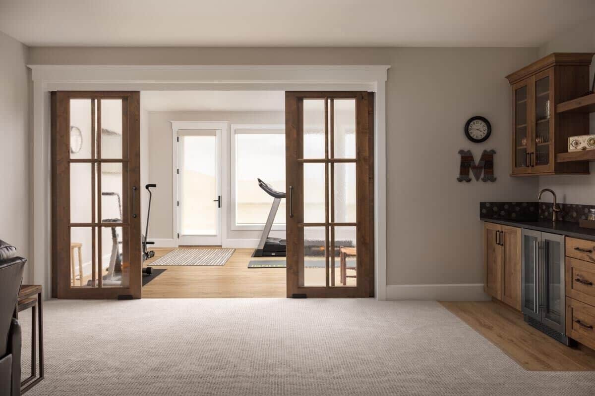 Rec room and gym connected by sliding glass doors.