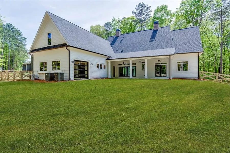 Rear view with a side-loading garage and a covered patio.