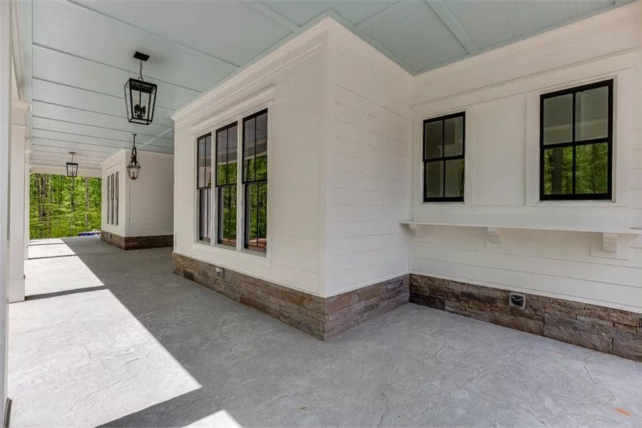 Rear porch with a paneled ceiling and concrete flooring.