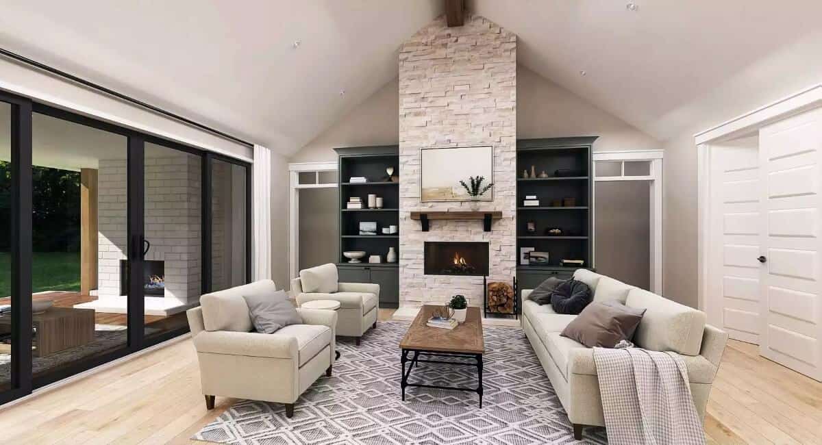 Great room with gray seats and a stone fireplace flanked by built-in cabinets.