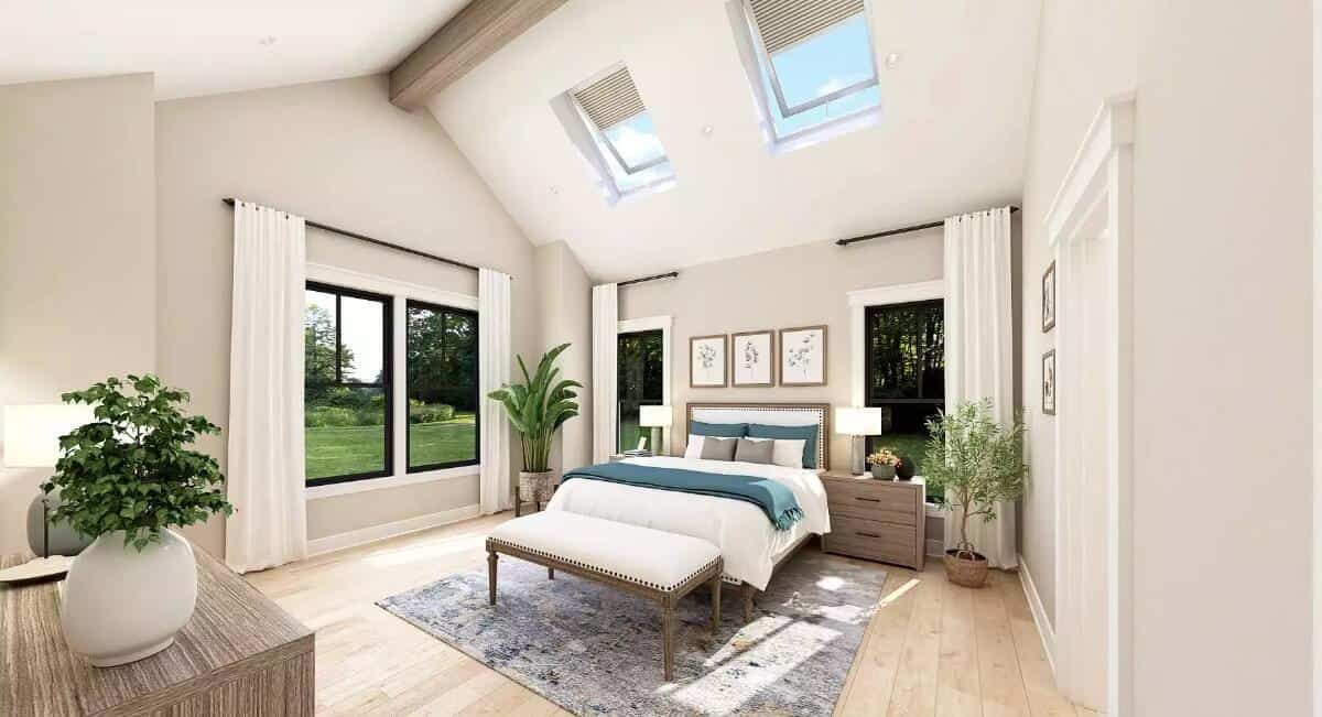 Primary bedroom with wooden furnishings and a cathedral ceiling fitted with skylights.