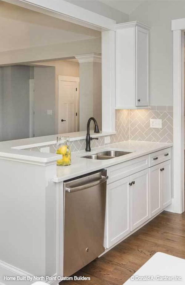 Two-tier peninsula fitted with a double bowl sink complete the kitchen.