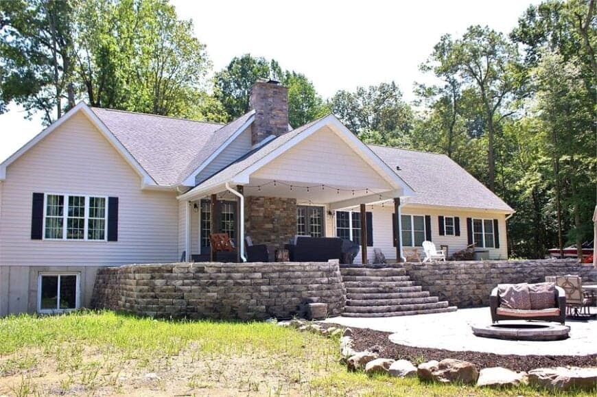 A large gable roof crowns the covered rear porch framed with wooden columns.