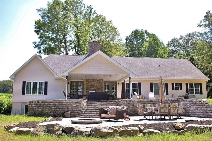 A farther view shows the open patio filled with plenty of chairs and a round fire pit.