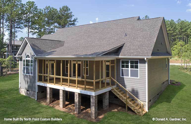 Rear exterior view showing the screened porch supported by stone columns