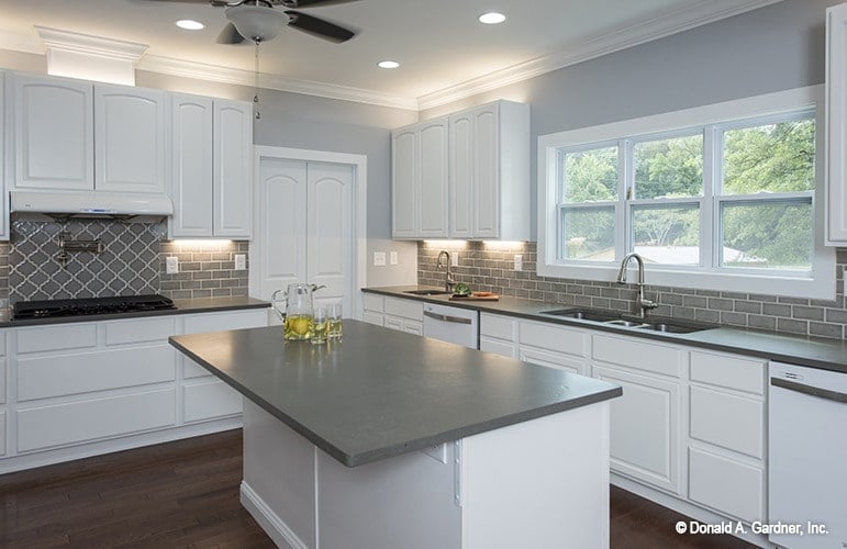 The white center island is crowned with a gray countertop.