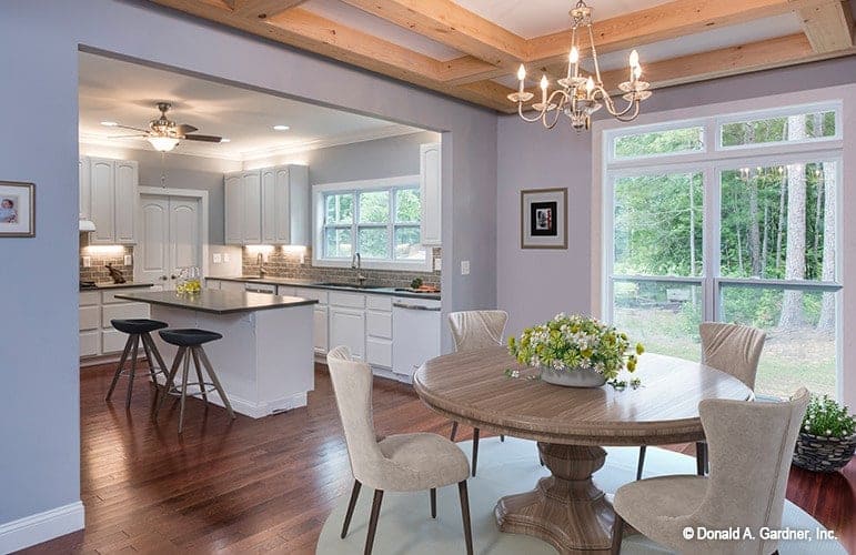 Breakfast nook with a round dining set and a candle chandelier that hangs from the wooden coffered ceiling.